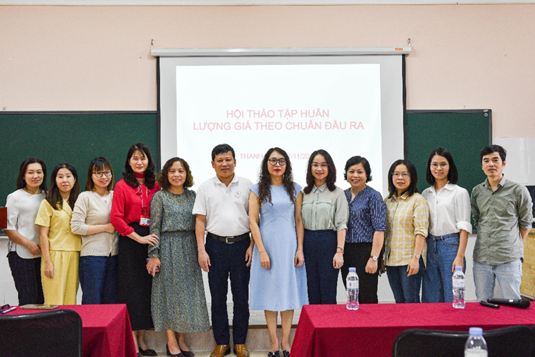 A group of people standing in front of a screen

Description automatically generated